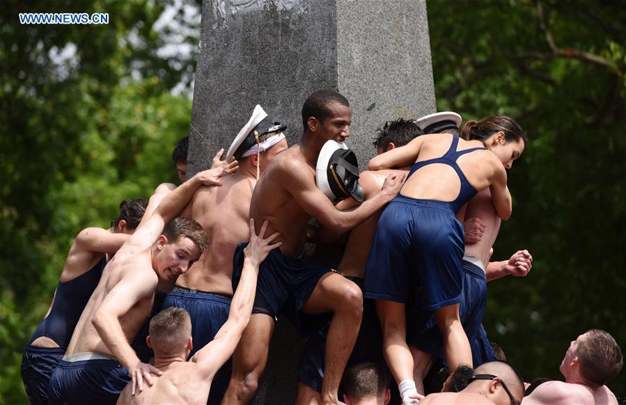 Plebes make a human wall to climb the Herndon Monument which is covered with vegetable shortening, at the U.S. Naval Academy (USNA) in Annapolis, Maryland, the United States, May 23, 2016.