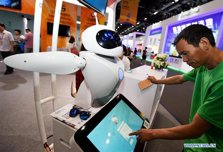 A man controls a robot at the fourth China Beijing International Fair for Trade in Services in Beijing, capital of China, May 30, 2016. 