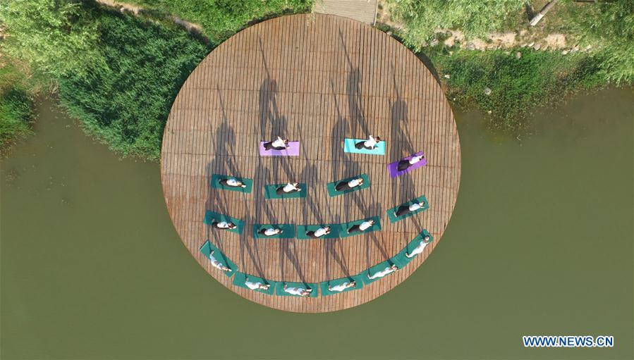 People practise yoga at the Longquan Lake Park in Wuzhi County of Jiaozuo, central China's Henan Province, June 18, 2016.