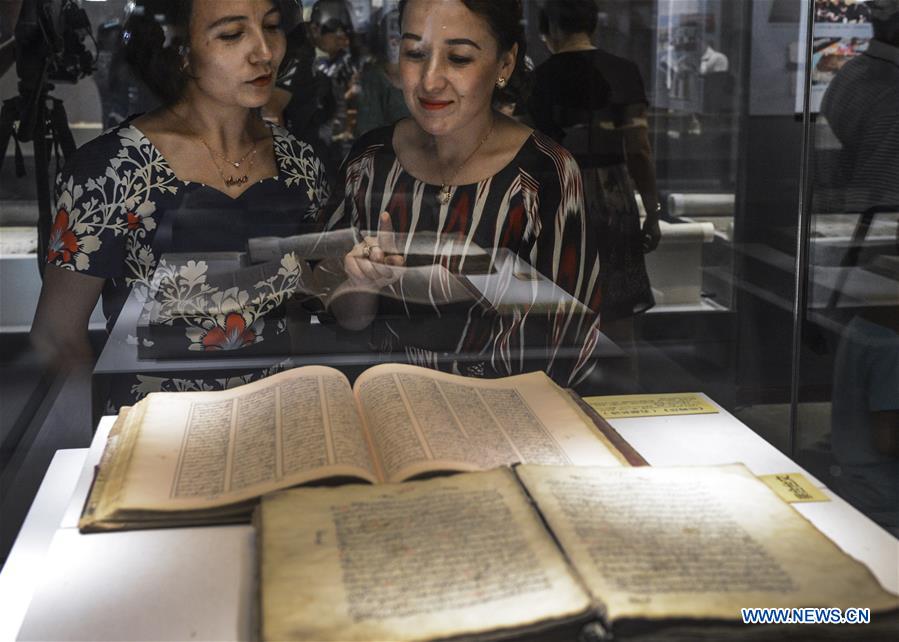 Visitors look at ancient books and documents of ethnic minorities in China displayed at Xinjiang Uygur Autonomous Region Musuem in Urumqi, capital of Xinjiang in northwest China, July 26, 2016. 