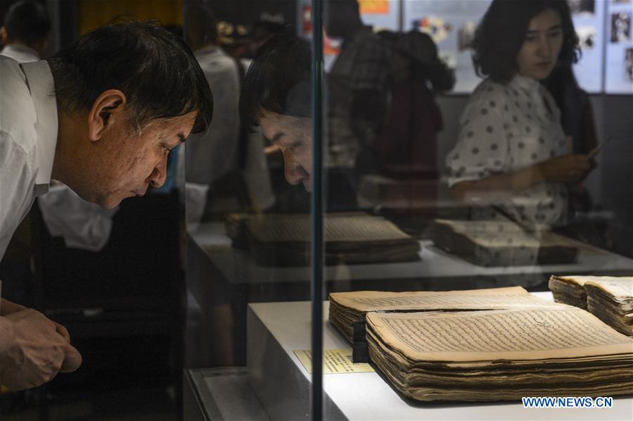 Visitors look at ancient books and documents of ethnic minorities in China displayed at Xinjiang Uygur Autonomous Region Musuem in Urumqi, capital of Xinjiang in northwest China, July 26, 2016. 