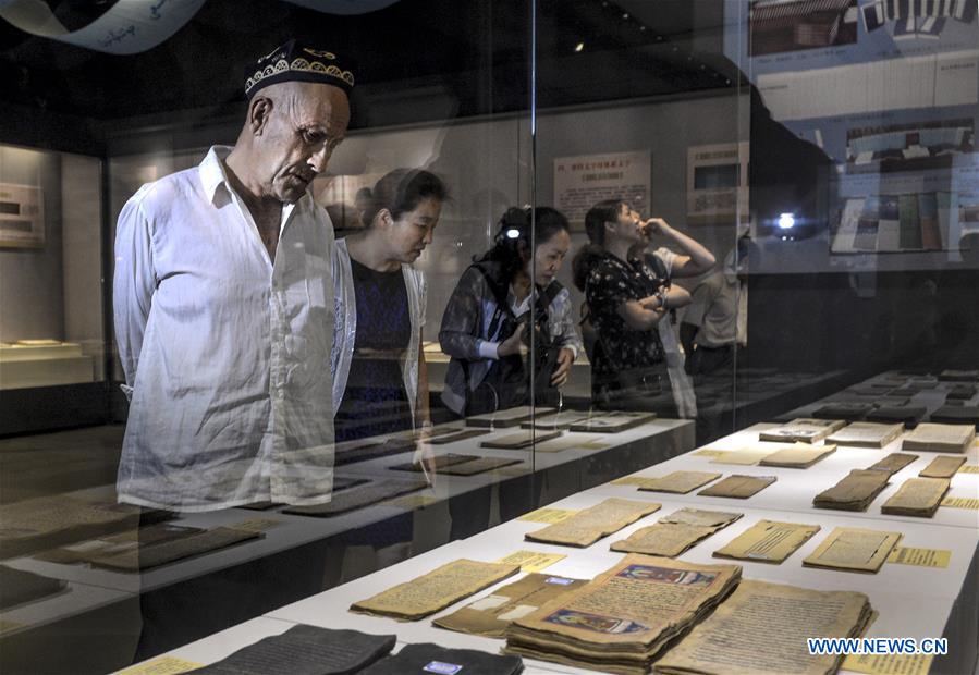 Visitors look at ancient books and documents of ethnic minorities in China displayed at Xinjiang Uygur Autonomous Region Musuem in Urumqi, capital of Xinjiang in northwest China, July 26, 2016. 