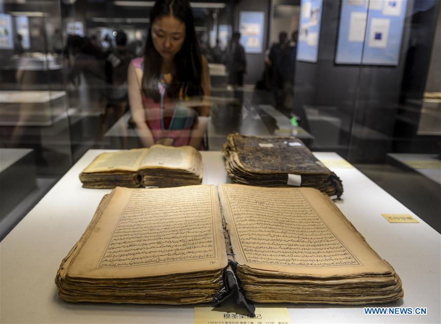 Visitors look at ancient books and documents of ethnic minorities in China displayed at Xinjiang Uygur Autonomous Region Musuem in Urumqi, capital of Xinjiang in northwest China, July 26, 2016. 