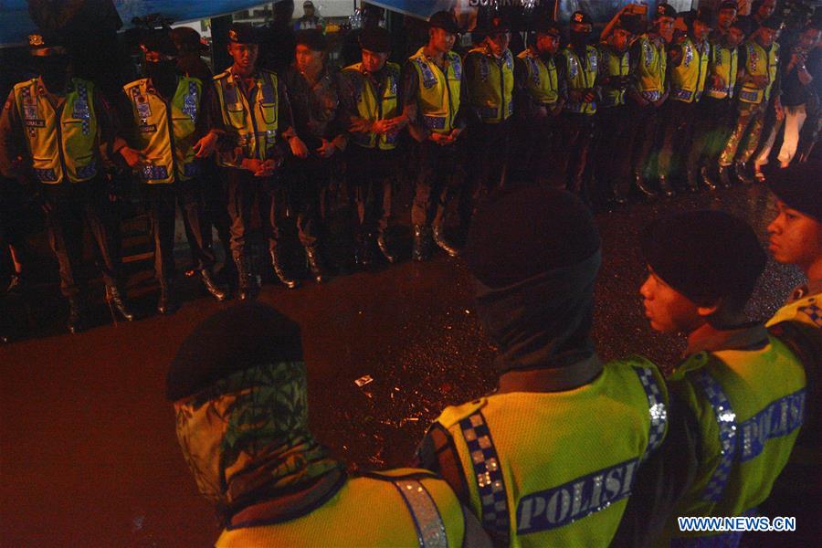 Police officers stand guard when an ambulance (not in frame) carrying the body of an executed prisoner leaves the port of Nusa Kambangan prison island in Cilacap, Central Java, Indonesia on July 29, 2016. 