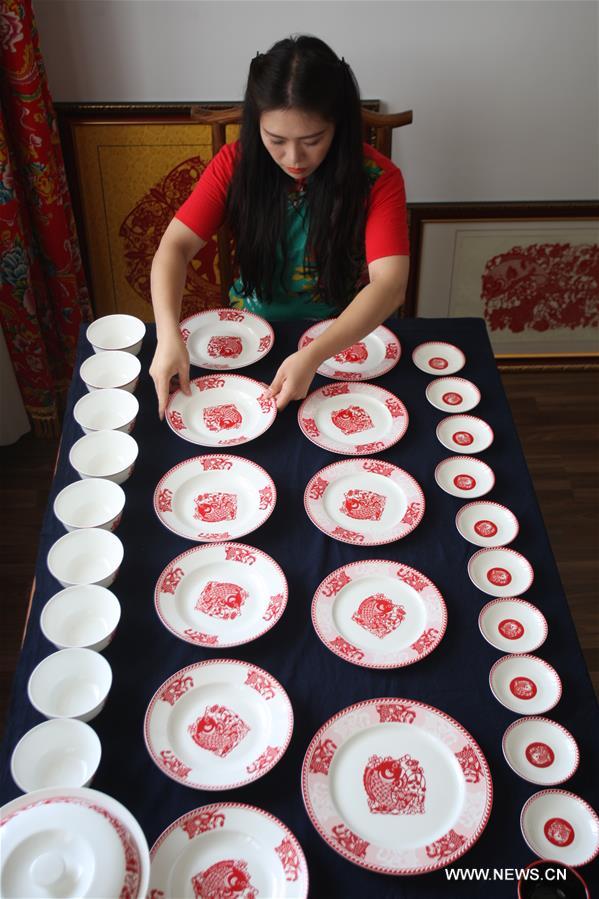 Liang has made over 40 kinds of handiworks of paper cutting as she combined the cutting with porcelain, statue, cloth and etc.