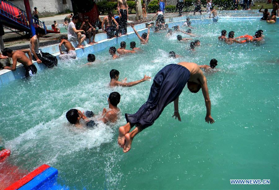 Boys cool themselves off in a swimming pool in northwest Pakistan's Peshawar, on Aug. 5, 2016. 