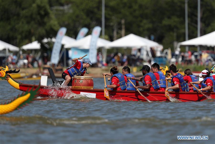 Dragon boat players cheer for the completion of a competition during the Hong Kong Dragon Boat Festival in New York (HKDBF-NY) held in Corona Park of New York, the United States, Aug. 7, 2016.