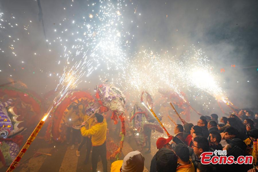 People perform dragon dance with a background of firecrackers in Yuqing County, southwest China\'s Guizhou Province, Feb. 16, 2019. Villagers gathered and performed dragon dances to celebrate the upcoming Lantern Festival,which falls on Feb. 19 this year.