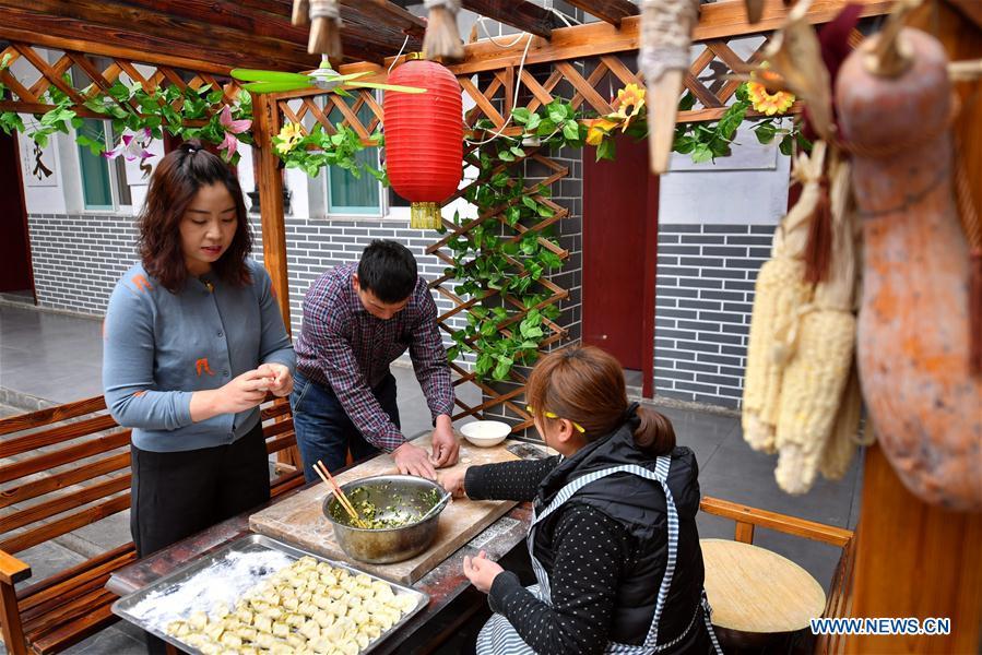 Duan Suhua (L), who runs a hostel, makes dumplings for tourists at her farmhouse in Niangziguan Village of Niangziguan Town in Pingding County, north China\'s Shanxi Province, on Feb. 26, 2019. China\'s efforts and success in poverty reduction can help other developing nations, said experts observing the country\'s ongoing Two Sessions. The Two Sessions refer to the annual gatherings of the National People\'s Congress (NPC) and the National Committee of the Chinese People\'s Political Consultative Conference, China\'s top legislature and political advisory body respectively. China has emerged as a global role model with efforts in structural transformation and industrial upgrading, lifting hundreds of millions of people out of poverty, said retired Lieutenant Colonel Muhammad Faruk Khan, a presidium member of Bangladesh\'s ruling Awami League. (Xinhua/Cao Yang)