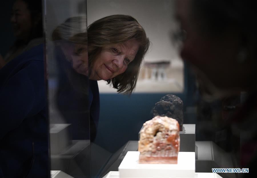 A woman views the displayed Seal of Empress Dowager Cixi at the exhibition titled \