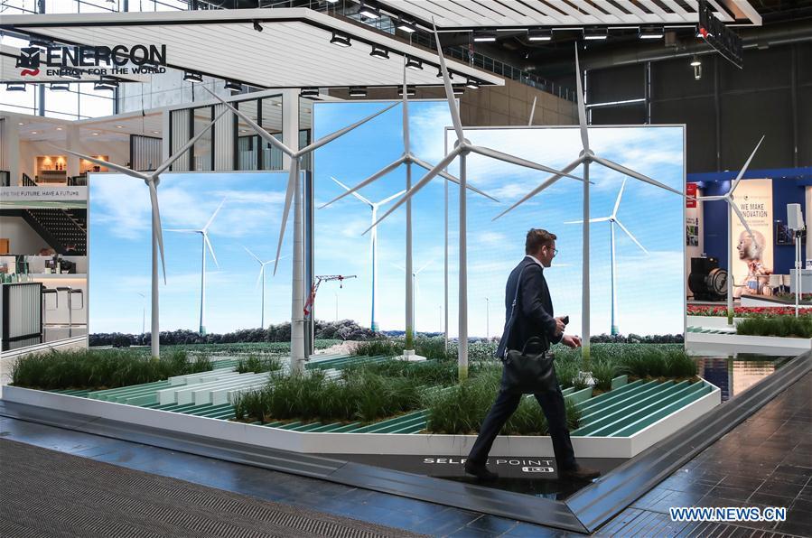 A visitor walks past the booth of Enercon during the 2019 Hanover Fair in Hanover, Germany, on April 1, 2019. With a total of 6,500 exhibitors from 75 countries and regions, the Hanover Fair shows the latest development of technologies for industrial use, including 5G network, artificial intelligence, light-weight manufacturing, among others. (Xinhua/Shan Yuqi)