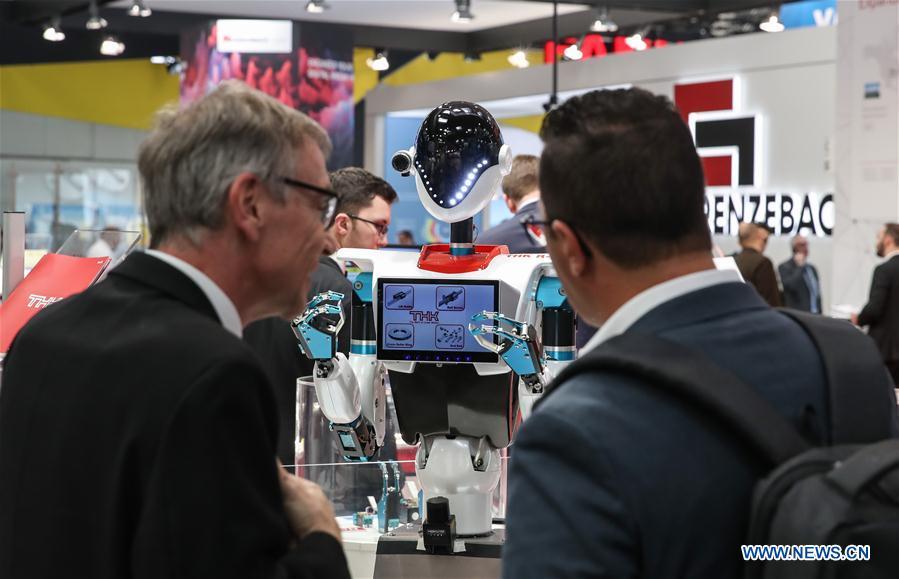 Visitors look at a robot displayed at the booth of THK during the 2019 Hanover Fair in Hanover, Germany, on April 1, 2019. With a total of 6,500 exhibitors from 75 countries and regions, the Hanover Fair shows the latest development of technologies for industrial use, including 5G network, artificial intelligence, light-weight manufacturing, among others. (Xinhua/Shan Yuqi)