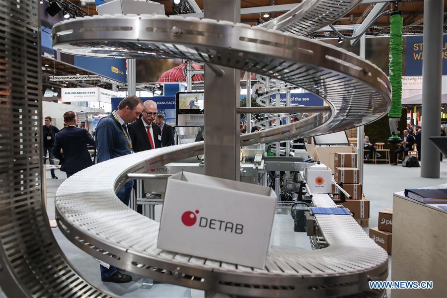 Visitors look at a conveyor displayed at the booth of Dateb Ecomat during the 2019 Hanover Fair in Hanover, Germany, on April 1, 2019. With a total of 6,500 exhibitors from 75 countries and regions, the Hanover Fair shows the latest development of technologies for industrial use, including 5G network, artificial intelligence, light-weight manufacturing, among others. (Xinhua/Shan Yuqi)