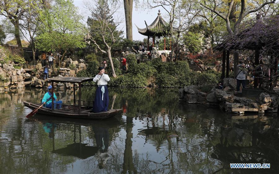 Tourists view an artist\'s performance in the Liuyuan garden during the Qingming Festival holidays in Suzhou, east China\'s Jiangsu Province, April 5, 2019. (Xinhua/Hang Xingwei)