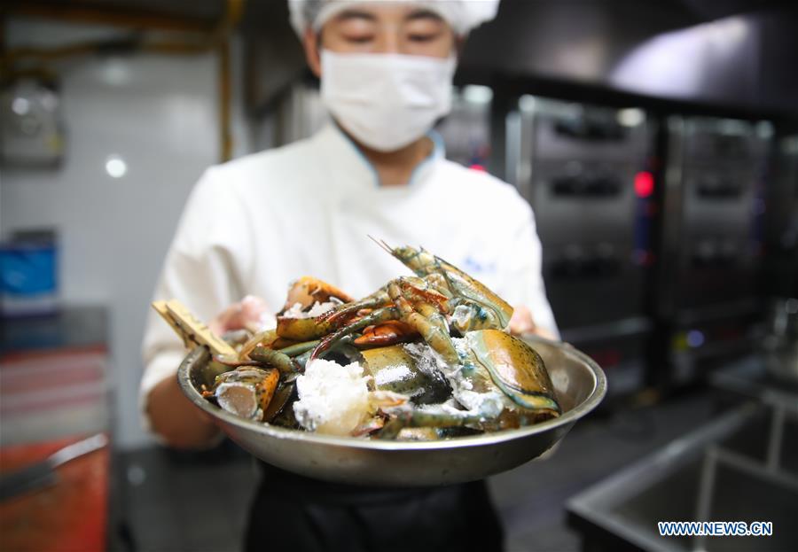 A chef shows American lobsters at one of the Fresh Hema supermarkets in Shanghai, east China, Aug. 8, 2018. It takes 36 hours at the earliest for the fresh lobsters from an aquafarm in Canada to be served on the dining tables of citizens in Shanghai after going through processes of transporting, inspecting, weighing, and selecting. Food of a particular place is an important symbol of local geographic and cultural characteristics. Food carries history and tradition, leads the tide of trade, strengthens diplomatic relations, disseminates and promotes culture. Food has been serving as connections between people around the world. In ancient times, food such as grapes, pomegranates, walnuts, coriander, cucumbers and sesame seeds were introduced to China along the Silk Road. Nowadays, thanks to the Belt and Road Initiative, red wine, coffee, dried fruits, meat, seafood, and dairy products from foreign countries enter the homes of ordinary people, turning daily meals into feasts with exotic cuisines. (Xinhua/Ding Ting)