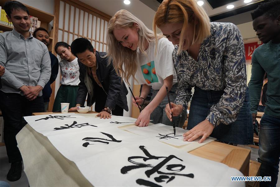 Foreign students learn calligraphy in Nanjing, capital of east China\'s Jiangsu Province, April 28, 2019. A cultural exchange event between young representatives from Nanjing and foreign students from Nanjing University of the Arts was held in Nanjing. (Xinhua/Ji Chunpeng)