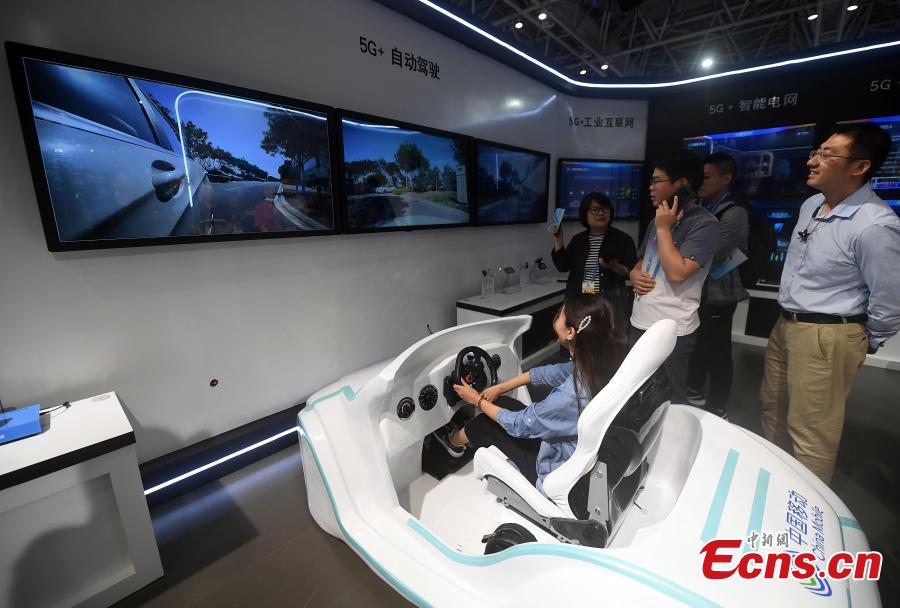 Visitors try out the self-driving experience in a booth by China Mobile at the second Digital China Summit in Fuzhou, Fujian Province, May 5, 2019. (Photo: China News Service/Zhang Bin)